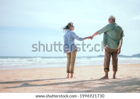 Elderly Asian couple relaxing on the beach family and smile