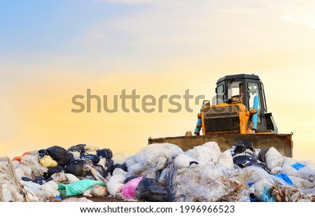 Garbage dump with plastic bags and food waste. Recycling of construction waste on junk yard. Refuse collection. Bulldozer dispose of rubbish at a landfill. Trash disposal area. Dozer on rubbish dump Royalty-Free Stock Photo #1996966523