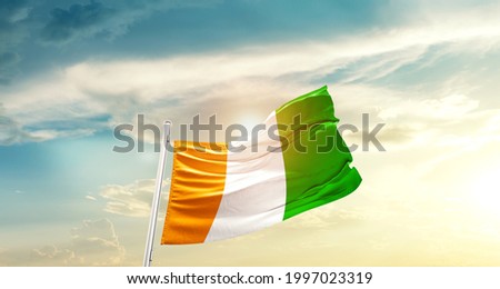 Côte d’Ivoire national flag waving in beautiful clouds.