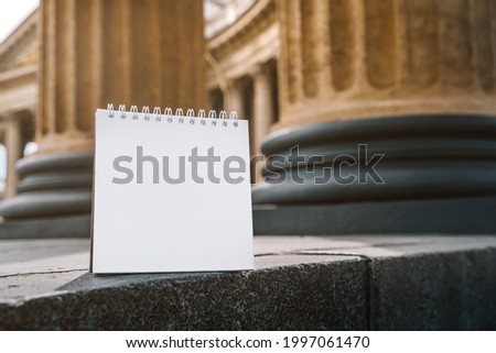 Blank paper notebook for copy space on the background of the columns of the Kazan Cathedral in St. Petersburg, education in Russia