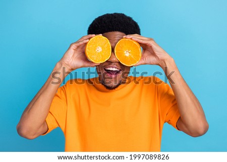 Portrait of attractive trendy cheery guy closing eyes orange slices having fun isolated over bright blue color background