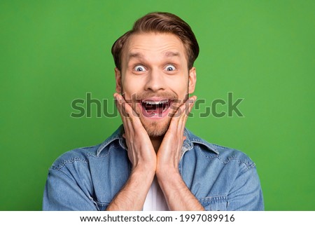 Photo of happy excited good mood crazy handsome man hold hands cheeks see huge sale isolated on green color background