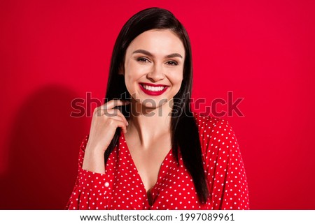 Photo of young optimistic brunette lady touch hair wear red dress isolated on vivid color background