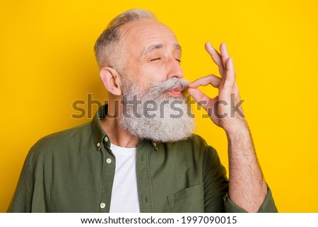 Photo portrait of elder man eating delicious food showing italian gesture isolated bright yellow color background Royalty-Free Stock Photo #1997090015