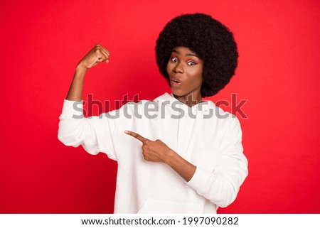 Photo of astonished brunette hair young lady point arm wear white sweatshirt isolated on red color background