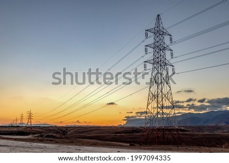 electric towers on mountain during sunset