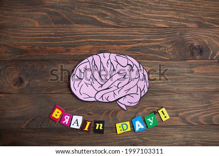 drawn cartoon human brain with color letters on a wooden background. creative concept brainstorm. creation of a business idea. world brain day july 22. copy space