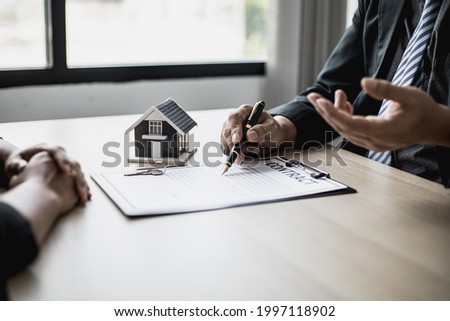 The employee is explaining the rent details and calculating the monthly rent to the tenant before signing the contract. The concept of renting a house.