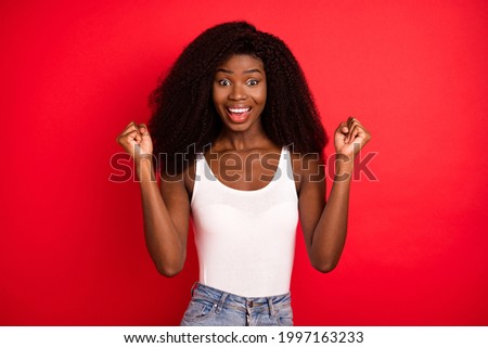 Photo of young african girl happy positive smile rejoice victory fists hands isolated over red color background