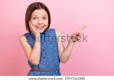 Portrait of attractive cheerful girl showing copy space look idea solution isolated over pink pastel color background