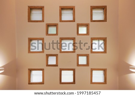 The Square windows in the room with natural lights and indirect lamps with beige background
