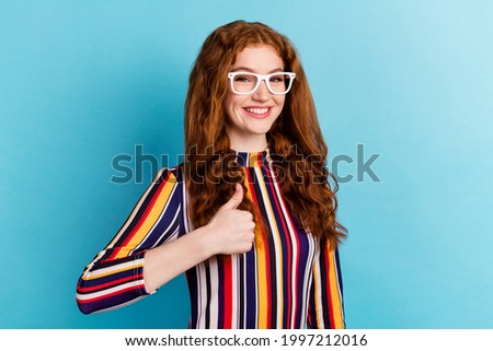 Photo of hooray red hairdo young lady show thumb up wear colorful shirt isolated on blue color background