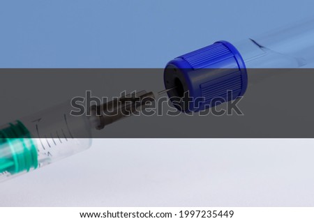 Estonia flag on the background of a medical bottle for injection and syringe for vaccination. Coronavirus vaccine