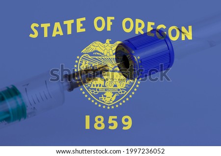 Oregon flag on the background of a medical bottle for injection and syringe for vaccination. Coronavirus vaccine