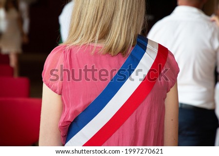 French blonde woman mayor with scarf france flag tricolor and pink dress during official celebration in France