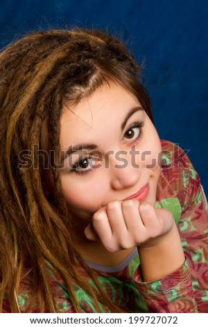 portrait of a beautiful young woman with dreadlocks against  a blue background