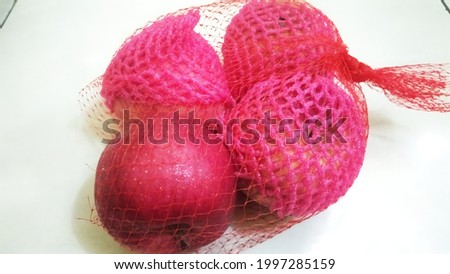 four fresh red apples in a fruit bag bought at the market on a white background