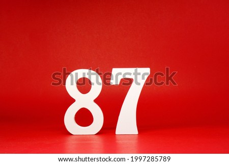 Eighty Seven ( 87 ) white number wooden Isolated Red Background with Copy Space - New promotion 87% Percentage  Business finance Concept 