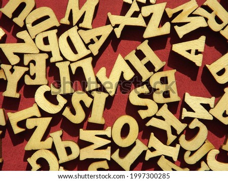 wooden letters of the English alphabet on burgundy suede as a background. High quality photo