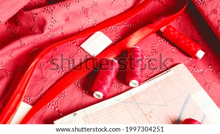 Tailoring. Fashion designer workspace top view. Sheets of professional sewing patterns, red fabric chalk pieces on cloth