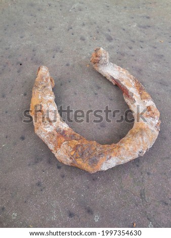 An old rusty horseshoe for a horse on the background of the surface of old metal.