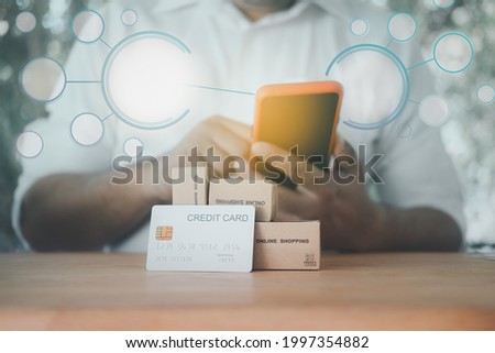 Businessman use smart-phone for pay money by online shopping with empty network icons with credit card and brown box. The concept of technology online payment.