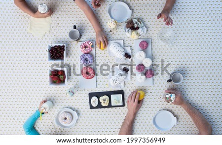 Top view of four people eating at festive dinner table with delicious food in cafe or restaurant