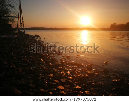 Beautiful sunset near water and river and stone shore