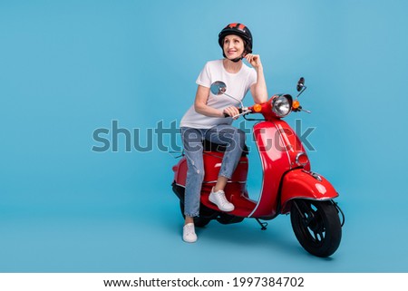 Portrait of attractive dreamy cheerful dreamy woman sitting on moped thinking isolated over bright blue color background Royalty-Free Stock Photo #1997384702