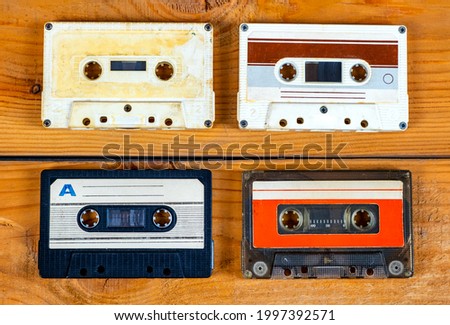 Four Old Audio Cassettes on a Wooden Planks Background closeup