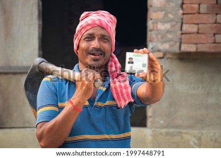 Rural Indian Farmer Showing aadhar card Royalty-Free Stock Photo #1997448791