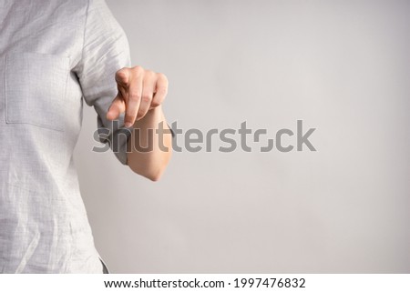 Tap the screen with your finger, use the virtual interface. businesswoman in a casual gray shirt makes a hand gesture