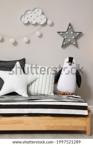 Comfortable floor bed with pillows and toy indoors. Cute kids room interior