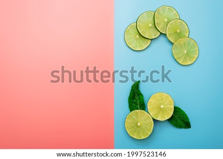 summer background concept: sliced orange, grapefruit, lemon, lime on pink and blue background