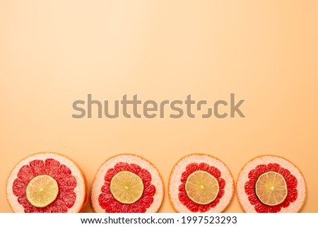 summer background concept: sliced grapefruit, lime on orange background