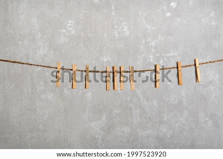 Wooden clothespins in rope waiting for clothes to come after laundry Royalty-Free Stock Photo #1997523920
