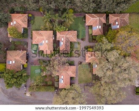 Aerial view of rural residential area with private homes between green fields.