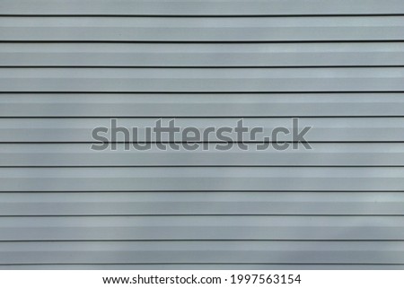 Gray vinyl siding. Background and texture of plastic siding.