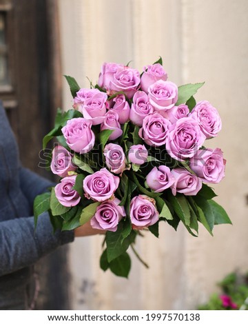 Beautiful bouquet of violet roses. The concept of a flower shop. A set of photos for a site or catalogue. Work florist. 