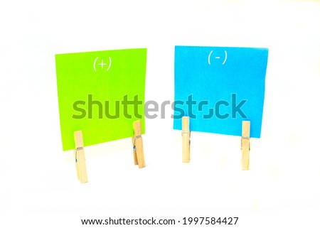 Notes on paper with wooden clothespins, blue and green stickers on white isolated background.