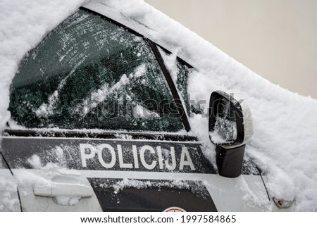 snow-covered police car in the parking lot, Riga, Latvia
