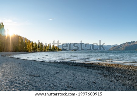 Landscape photograph of the Lake Wanaka in the South Island of New Zealand. Blue sky, yellow autumn and water reflection.