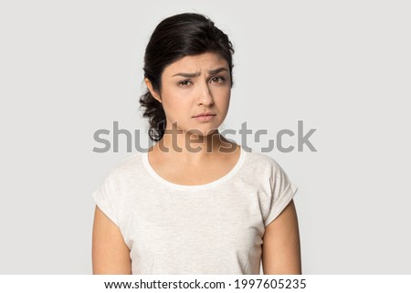 Portrait of unhappy young Indian woman isolated on grey studio background look at camera feeling sad crying. Upset millennial mixed race female distressed with bad negative news. Failure concept. Royalty-Free Stock Photo #1997605235