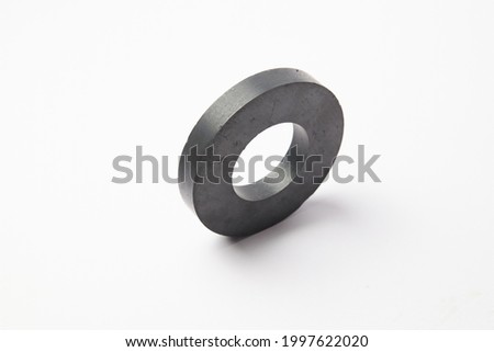 Circular black ferrite ring magnet isolated on a white background Royalty-Free Stock Photo #1997622020