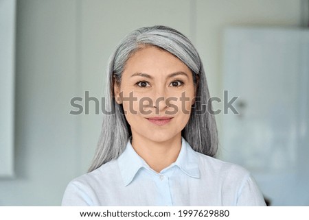 Happy confident middle aged Asian older senior female lawyer businesswoman corporation ceo in modern office looking at camera. Business woman executive concept. Closeup portrait headshot. Royalty-Free Stock Photo #1997629880