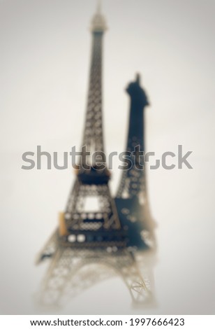 Defocused blur background of miniatur Eiffel tower and silhouette  