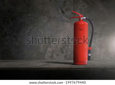 vertical fire extinguisher. Color red. Isolated on cement wall background.