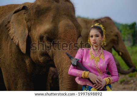 The young lady is standing together with her best friend elephant.