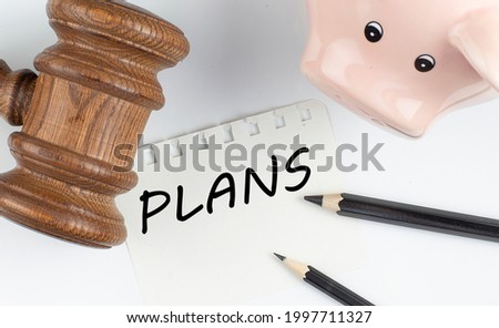 PLANS text on paper with gavel and piggi bank, business