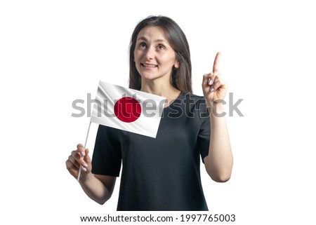 Happy young white woman holding flag of Japan and points thumbs up isolated on a white background.